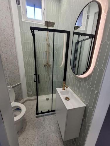 La salle de bains est pourvue de toilettes, d'un lavabo et d'un miroir. dans l'établissement La Villa - Charmant logement proche Paris, à Saint-Mandé
