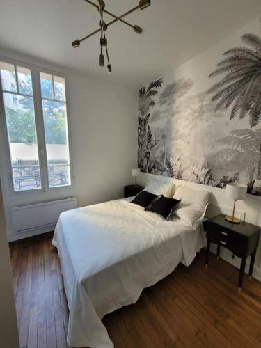 - une chambre avec un lit blanc et une grande fenêtre dans l'établissement La Villa - Charmant logement proche Paris, à Saint-Mandé