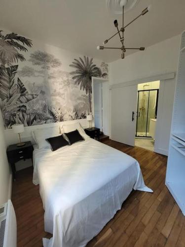 - une chambre avec un lit blanc et une peinture murale dans l'établissement La Villa - Charmant logement proche Paris, à Saint-Mandé
