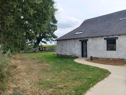 a white building with a tree next to a field at ~ Au calme à la campagne ~ in La Mézière