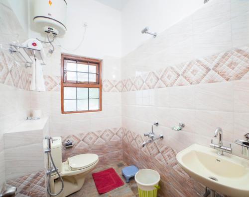 a bathroom with a toilet and a sink at Tulips Resorts - Elkhill in Ooty