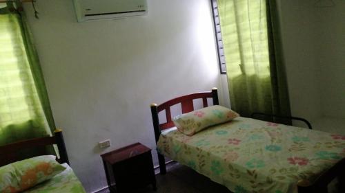 a small bedroom with a bed and two windows at Villa Myrian in Villanueva