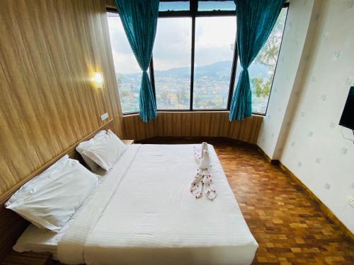 a bedroom with a bed with twoeddy bears on it at Tulips Resorts - Elkhill in Ooty