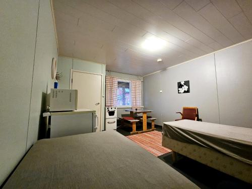 a room with two beds and a desk and a kitchen at Lomakylä Lapponia in Inari