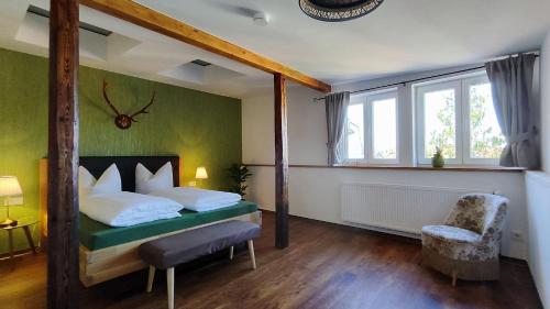 a bedroom with a bed and a chair and a window at Traditions - Hotel "Zur Tanne" in Wernigerode