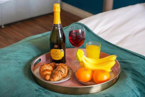 a tray of food with a bottle of wine and fruit at Stylish Apartment - Walking Distance to the City Centre - Free Parking, Fast Wi-Fi and SmartTV with Netflix by Yoko Property in Coventry