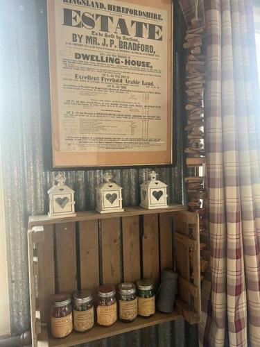 a wooden shelf with jars on it with a sign at Bridie -rose with wood tub country retreat in Kington