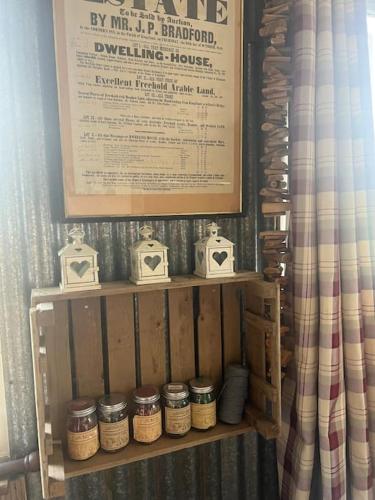 a wooden shelf with knick knacks on top of it at Bridie -rose with wood tub country retreat in Kington