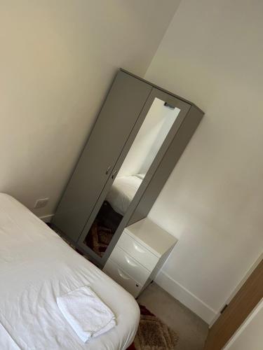 a mirror next to a bed in a bedroom at Spacious 2 Bedroom Apartment in Woolwich Arsenal in Woolwich