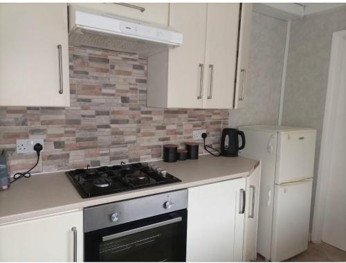 a kitchen with a stove top oven next to a refrigerator at Adorable Double Room in Middlesbrough