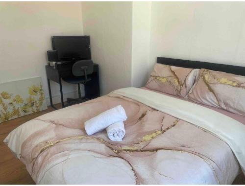 a bed with a towel sitting on top of it at Adorable Double Room in Middlesbrough