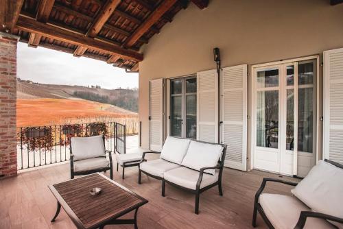 a porch with chairs and a table and a view at Réva Resort in Monforte dʼAlba