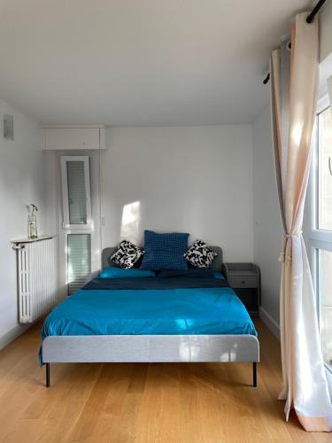 een slaapkamer met een blauw bed en een raam bij Luckyhouse Chatou-ville des impressionnistes - 10km Paris La Défense 20km Stade de France in Chatou