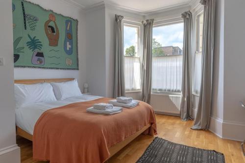 a bedroom with a bed with two towels on it at Gorgeous Garden Apartment *Cafes/Bars/Beach within minutes* in Kent