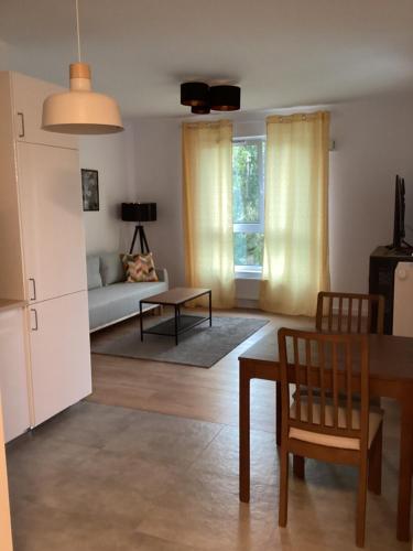 ein Wohnzimmer mit einem Tisch und einem Sofa in der Unterkunft Chopin airport Apartment in Warschau