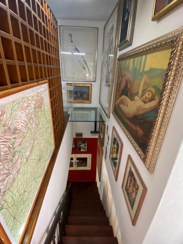 a stairway with paintings and pictures on the walls at B&B Al Casel in Tovena