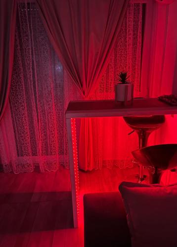 ein rotes Zimmer mit einem Tisch und roten Vorhängen in der Unterkunft S-E-N in Bosanski Novi