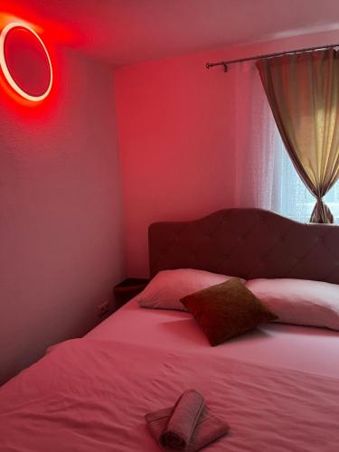 1 dormitorio con 1 cama con luz roja en S-E-N, en Bosanski Novi