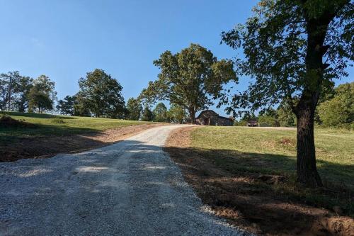 a dirt road with a tree on the side of a field at Enjoy Ozark History in Style! in Hasty