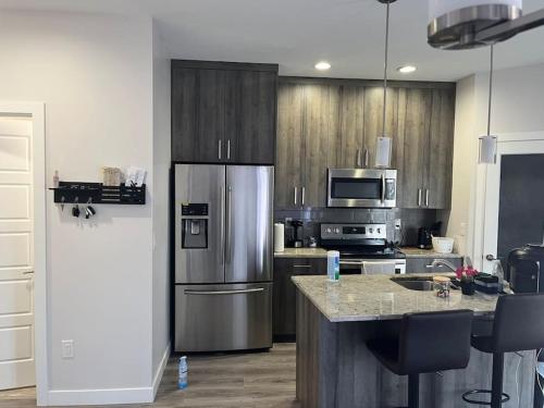a kitchen with a stainless steel refrigerator and a counter at Home for yourself in Winnipeg