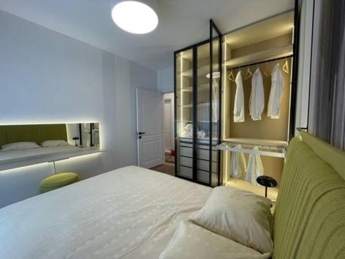 1 dormitorio con cama blanca y armario en Grandeur City Centre Apartment, en Pristina