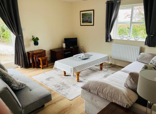 a living room with a couch and a table at Hillcrest Lodge, Private apartment on Lough Corrib, Oughterard in Galway