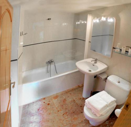 a bathroom with a sink and a toilet and a bath tub at Hostal Casa Martina in Guadalaviar