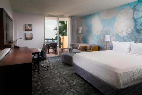 a hotel room with a bed and a desk and a desk at Courtyard Miami Dadeland in Miami