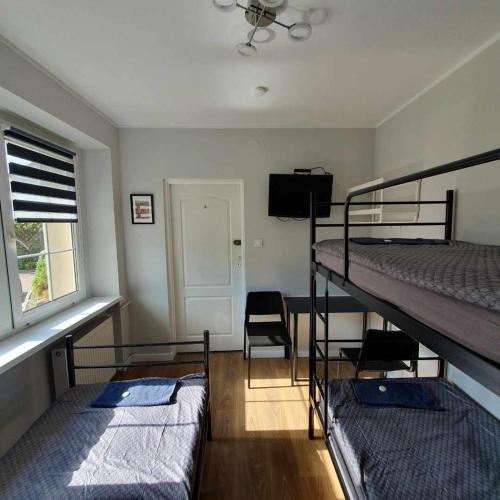 a room with two bunk beds and a window at POKOJE & NOCLEGI de'Górska in Poznań