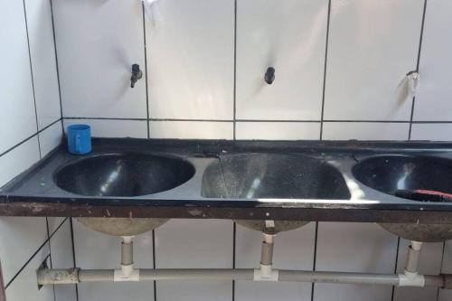 a pair of sinks in a public bathroom at casa grande e confortável in Pirapora