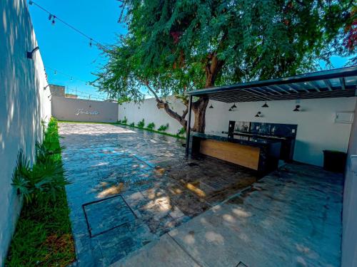 un patio con un banco frente a un edificio en tecoman colima Tamarindo, en Tecomán