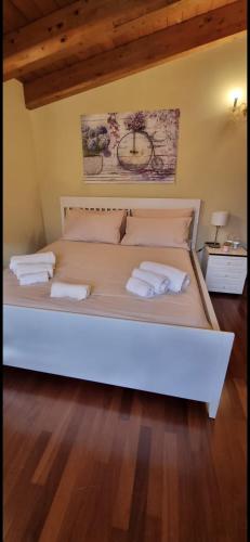 a large white bed with two white towels on it at Santa Maria Apartments in Forino