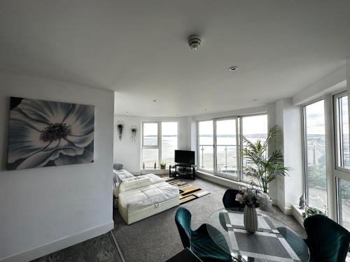 een woonkamer met een bank en een tafel bij Stunning Ocean & City View APT in Swansea