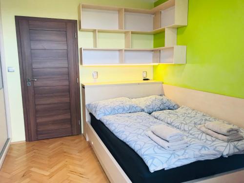 a small bedroom with a bed with towels on it at Nový apartmán v Ostravě u Mišky s akváriem a výhledem z balkonu na Beskydy in Ostrava