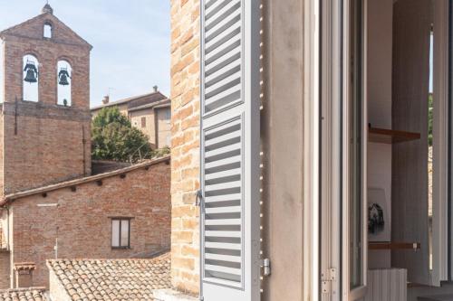 a door to a building with a church in the background at Il Cielo di Raffaello 2 in Urbino
