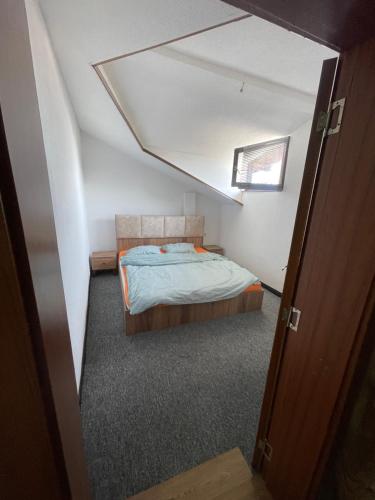 Dormitorio pequeño con cama en el ático en FG 3 Apartment, en Gnjilane