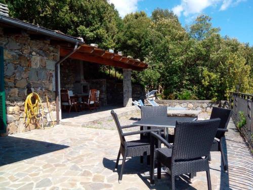 a patio with a table and chairs and a stone building at La Casetta in Corniglia