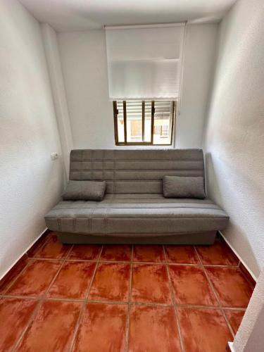 a couch sitting in a room with a window at Chalet en La Mata a 50 metros de la playa in Torrevieja