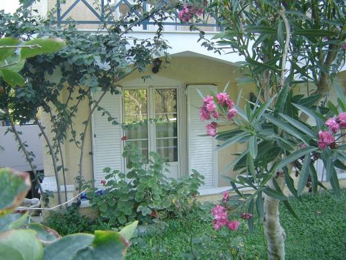 a front door of a house with pink flowers at Paradise Hotel in Samos