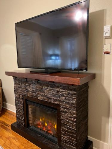 einen TV über einem Kamin mit einem TV darüber in der Unterkunft Opus House Historic Natchitoches in Natchitoches