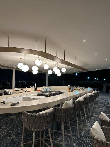 a large room with a bar with chairs and lights at Maritima in Nuevo Vallarta
