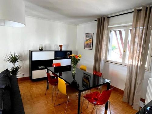 a dining room with a black table and red chairs at Pau centre vue sur les Pyrénées pour 2 nuits au minimum in Pau