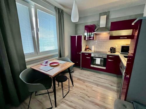 Il comprend une petite cuisine avec une table et des chaises en bois. dans l'établissement The Elegant Luxury Apartment - Boru, à Banská Bystrica