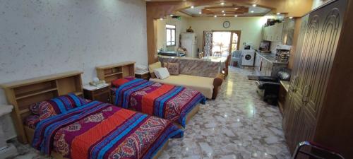 a hotel room with two beds and a kitchen at Adorable studio with farm view in Nijil