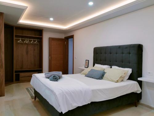 a bedroom with a large bed with a green headboard at Villa Agate in Midoun