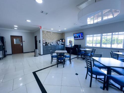 una sala da pranzo con tavoli e sedie in un ristorante di American Inn Madill a Madill