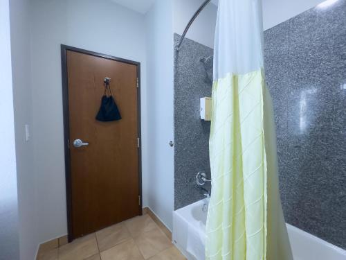 a bathroom with a shower and a shower curtain at American Inn Madill in Madill