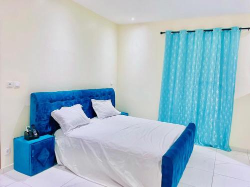 een blauw bed in een kamer met een blauw gordijn bij Villa avec piscine in Somone