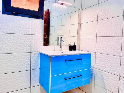 een badkamer met een blauwe wastafel en een spiegel bij Villa avec piscine in Somone
