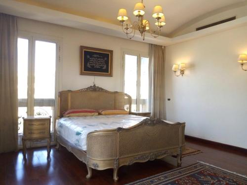 Schlafzimmer mit einem Bett und einem Kronleuchter in der Unterkunft Heaven new Cairo in Kairo